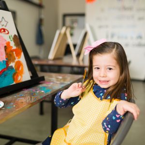 portrait of a pretty elementary girl showing her new artwork