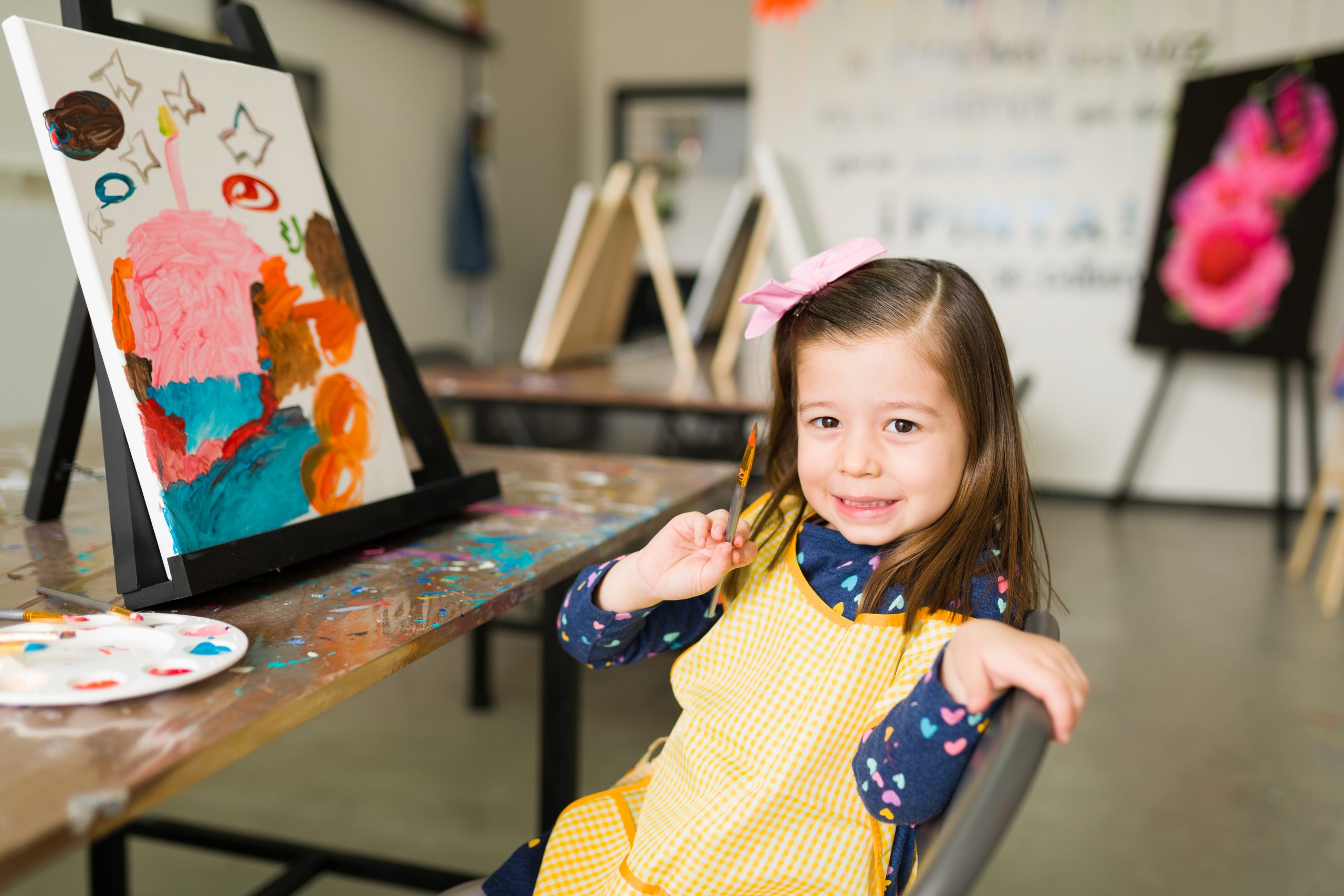 portrait of a pretty elementary girl showing her new artwork