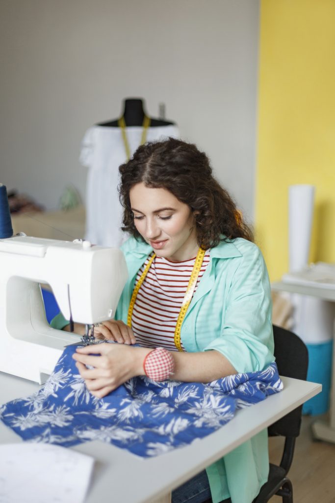 pretty seamstress in colorful shirt and striped t shirt dreamily