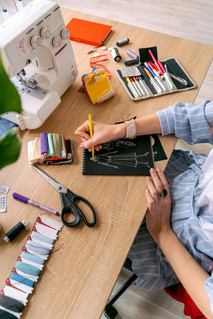Creative fashion designer sketching clothing designs in a vibrant studio.